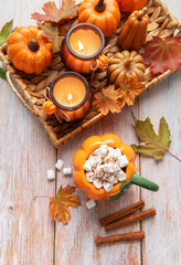 Cozy autumn arrangement with hot chocolate and candles