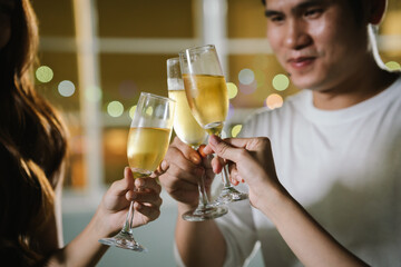Friends clinking glasses of red and white wine in a cheerful toast, smiling and celebrating together in a joyful outdoor gathering.