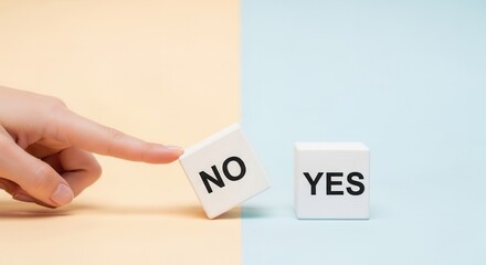 A hand pushes a white block labeled NO on a beige surface while a YES block sits on a blue surface split background