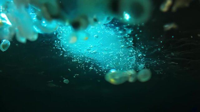 Visualize biofilm layers rusty water pipe breaking apart fragments droplets escape flowing water, carrying glowing Legionella cells pathogens float downstream, symbolizing contamination