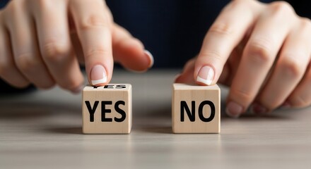 Two hands hover above wooden cubes one displaying YES and the other NO on a light tabletop
