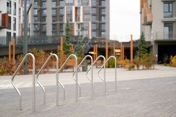 urban bike rack in modern residential area showcasing sustainable city living. sleek metal design complements contemporary architecture, inviting eco-friendly transportation solutions for residents