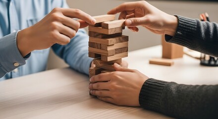 Close-up of hands playing a wooden block removal game, teamwork concept.