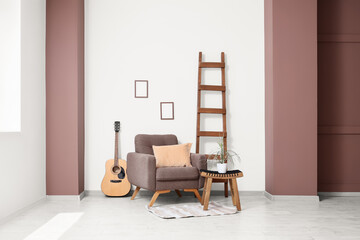 Stylish interior of living room with comfortable armchair and wooden ladder
