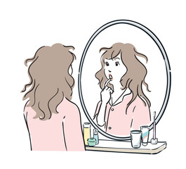 鏡をみて驚くパジャマ姿の女性
