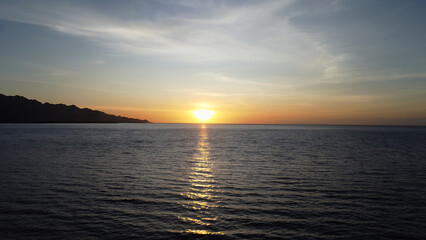 Obraz premium Serene Sunset over the Ocean with Reflection of Sun Rays