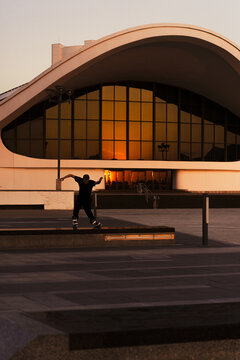 Man performing a trick on roller skates at sunset, urban environment