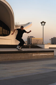 Man performing a trick on roller skates at sunset, urban environment