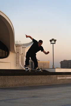 Man performing a trick on roller skates at sunset, urban environment