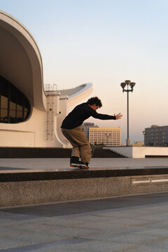 Man performing a trick on roller skates at sunset, urban environment