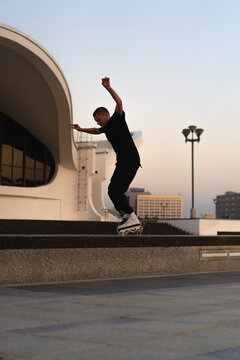 Man performing a trick on roller skates at sunset, urban environment