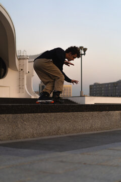 Man performing a trick on roller skates at sunset, urban environment