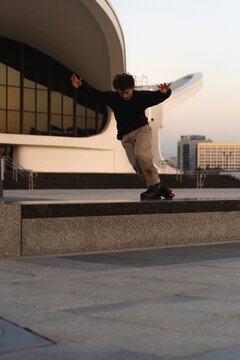 Man performing a trick on roller skates at sunset, urban environment