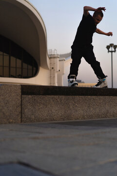 Man performing a trick on roller skates at sunset, urban environment