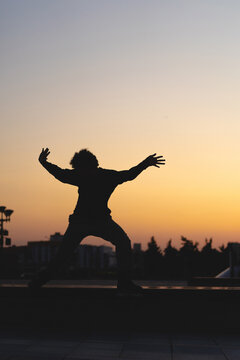 Man performing a trick on roller skates at sunset, urban environment