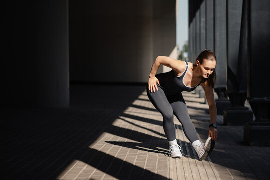 Woman Stretching in Urban Setting