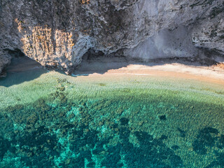 Aerial top down view of Spiaggia di Sansone beach on Elba Island, Italy – turquoise water and rocky coastline