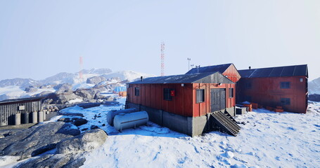 A remote research facility stands in a pristine snowy landscape, surrounded by rocky terrain and distant peaks. © icetray