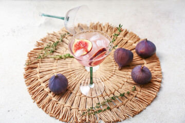 Composition with glass of tasty fig lemonade and ingredients on white grunge background, closeup
