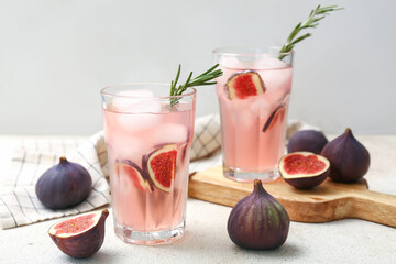 Glasses of fresh fig lemonade on white grunge table, closeup