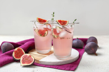 Composition with glasses of fresh fig lemonade on white grunge table, closeup