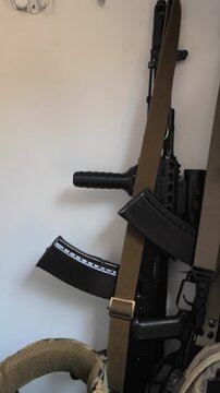 Vertical video. A AK-47 or AK-74 assault rifle, bulletproof vest, tactical helmet and ammunition of a soldier of the armed forces of Ukraine are in a locker in the barracks.