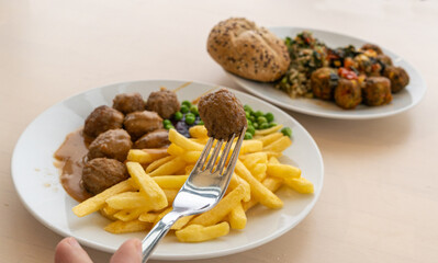 Meatballs with french fries, green peas, bechamel sauce and cranberry jam