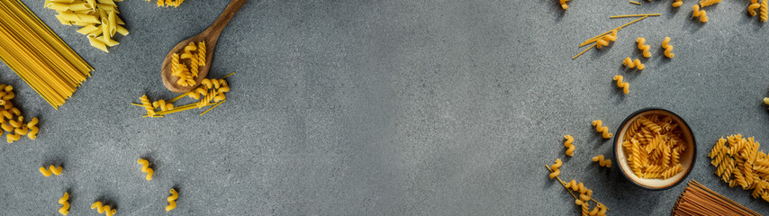 Pasta assortment on a gray background with copy space