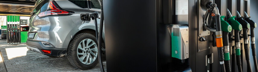 Fototapeta premium Modern car refueling at a gas station