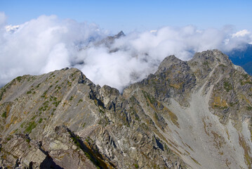 北アルプス、奥穂高岳から望む涸沢岳、北穂高岳と雲間の槍ヶ岳