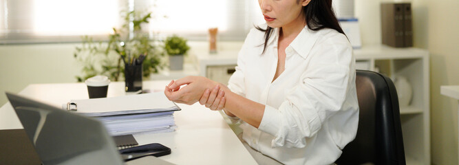 Woman have wrist pain after work hard in office feeling so pain and illness with Office syndrome symptom, healthcare office syndrome concept.