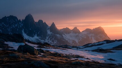 A cold mountain pass with patches of snow, jagged peaks, and a soft orange sunrise