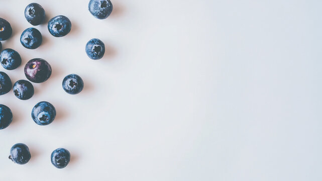 Purple fresh berries scattered around on white background. Food temlate photo. Vintage hues.