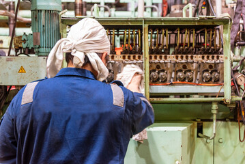 Fototapeta premium Marine engineer during his work in ships engine room, he is adjusting cylinder liner lubrication for the main engine.
