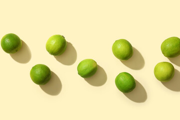 Many fresh ripe limes on yellow background