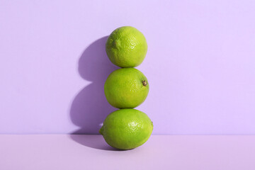 Fresh ripe limes on lilac background