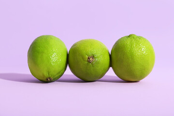 Fresh ripe limes on lilac background