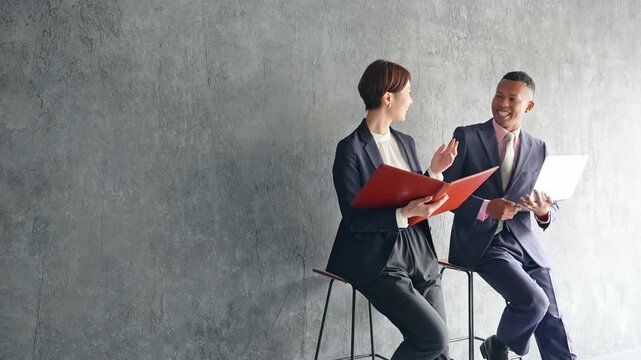 おしゃれな部屋で会話する黒人男性ビジネスマンと日本人女性スタッフ