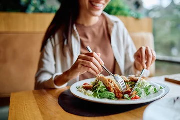 Fotobehang Kruidenier Woman smiling, eating fresh chicken salad in a restaurant. Promoting healthy eating, lunch, diet, wellness, and lifestyle  © we.bond.creations