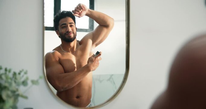 Man, mirror and spray armpit in bathroom for hygiene, smell fresh and grooming for odor control. Male person, reflection and deodorant for clean fragrance, body cosmetic and sweat prevention at house