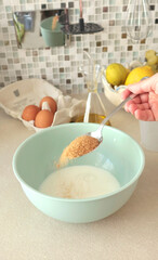 Anonymous mixes dough in bowl and add brown tropical sugar. Healthy eating with organic, gluten-free ingredients. Home cooking.