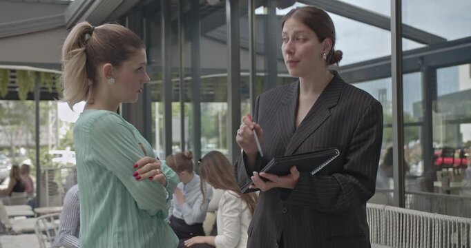 Businesswomen actively engaging in a team meeting, exchanging ideas and collaborating on new strategies. Their positive interaction highlights effective communication and successful teamwork.