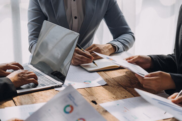 Financial analysts analyze business financial reports on a digital tablet planning investment project during a discussion at a meeting of corporate showing the results of their successful teamwork.