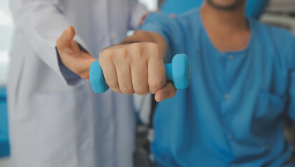 Physiotherapist man giving exercise with dumbbell treatment About Arm and Shoulder of athlete male patient Physical therapy concept