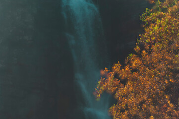 Autumn colors frame the view of Njupeskär, Sweden's largest waterfall, in a serene landscape