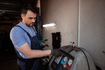Skilled technician checks air conditioning equipment in garage during daytime