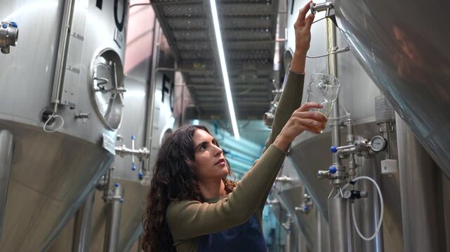 Female brewmaster tasting freshly brewed craft beer
