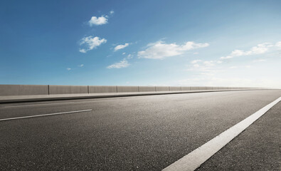 Empty Asphalt Highway Under Clear Blue Sky on Bright Sunny Day.