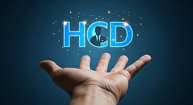 Hand reaching for glowing HCD letters with a businessman silhouette on a dark blue background