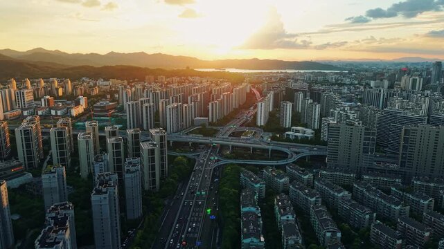 Aerial view of a residential buildings alongside a multilane highway interchange filled with moving vehicles